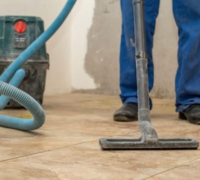 the man vacuums the tile after laying. preparation for jointing the man vacuums the tile after laying. preparation for jointing.